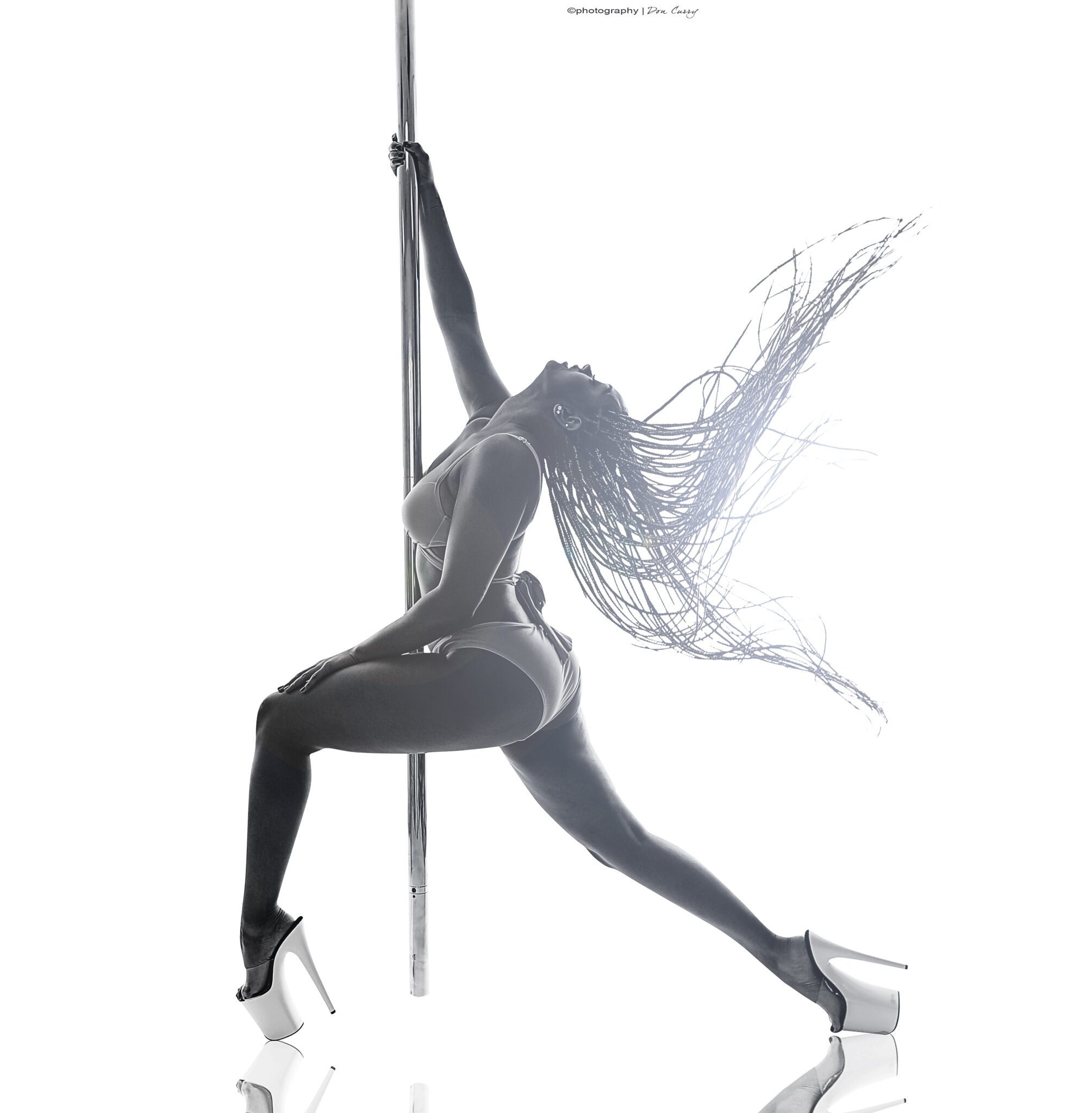 pole dance instructor legz flips hair while holding on to the pole